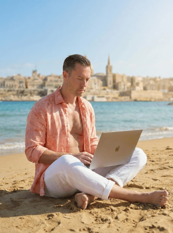 Remote virtual assistant working on laptop by Malta coastline with Valletta skyline